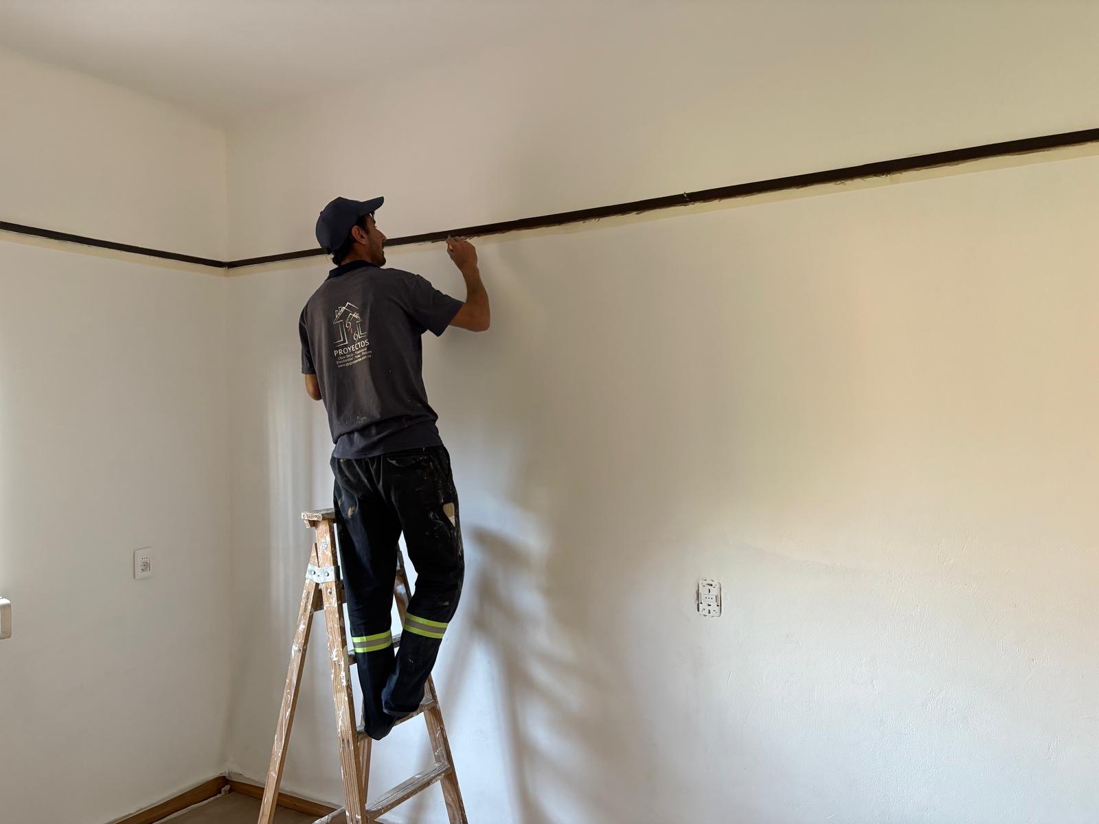 Empleado uniformado de G&G pintando el interior de Las Violetas
