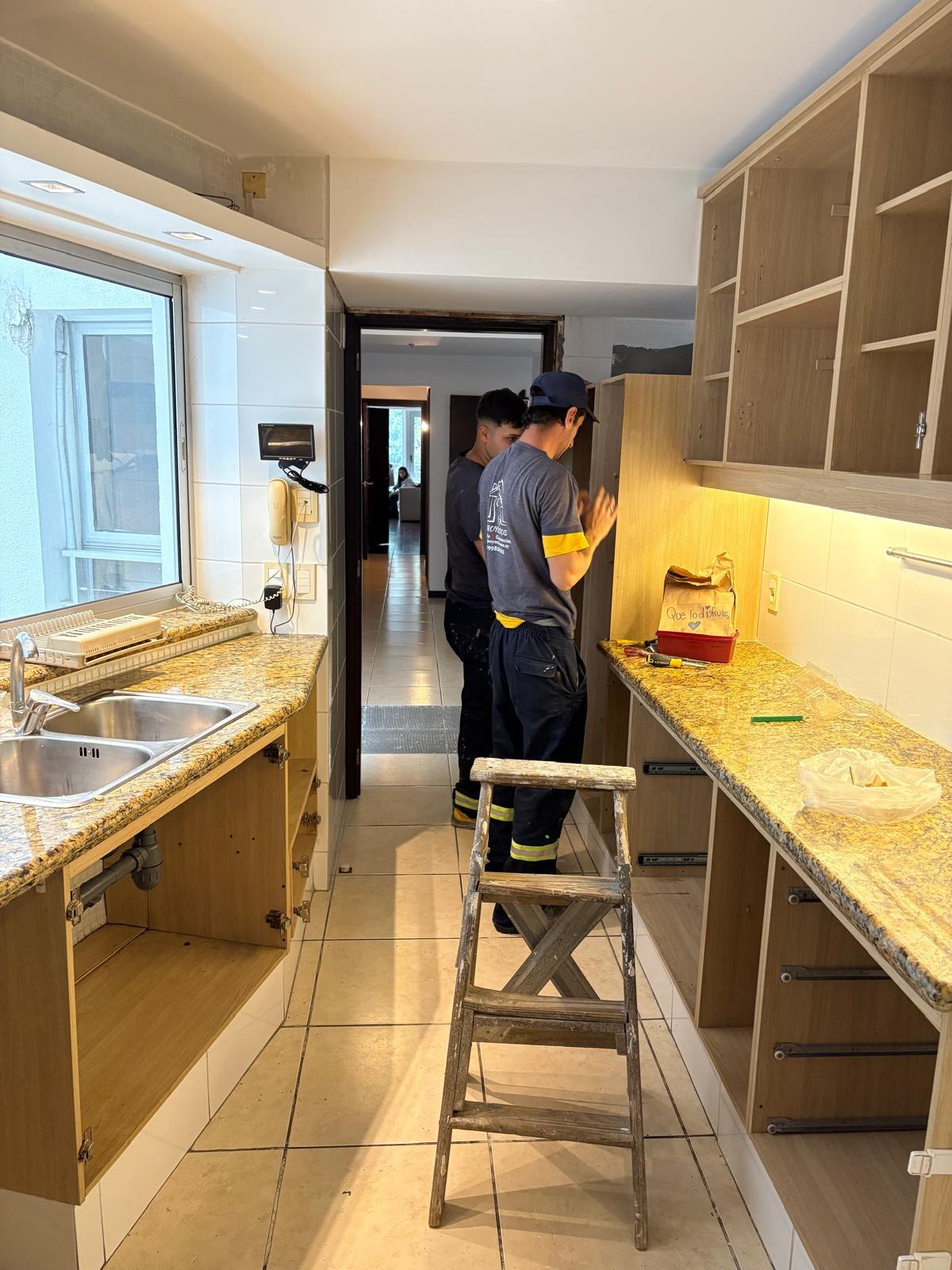 Montaje del mobiliario a medida de una cocina por trabajadores uniformados de G&G