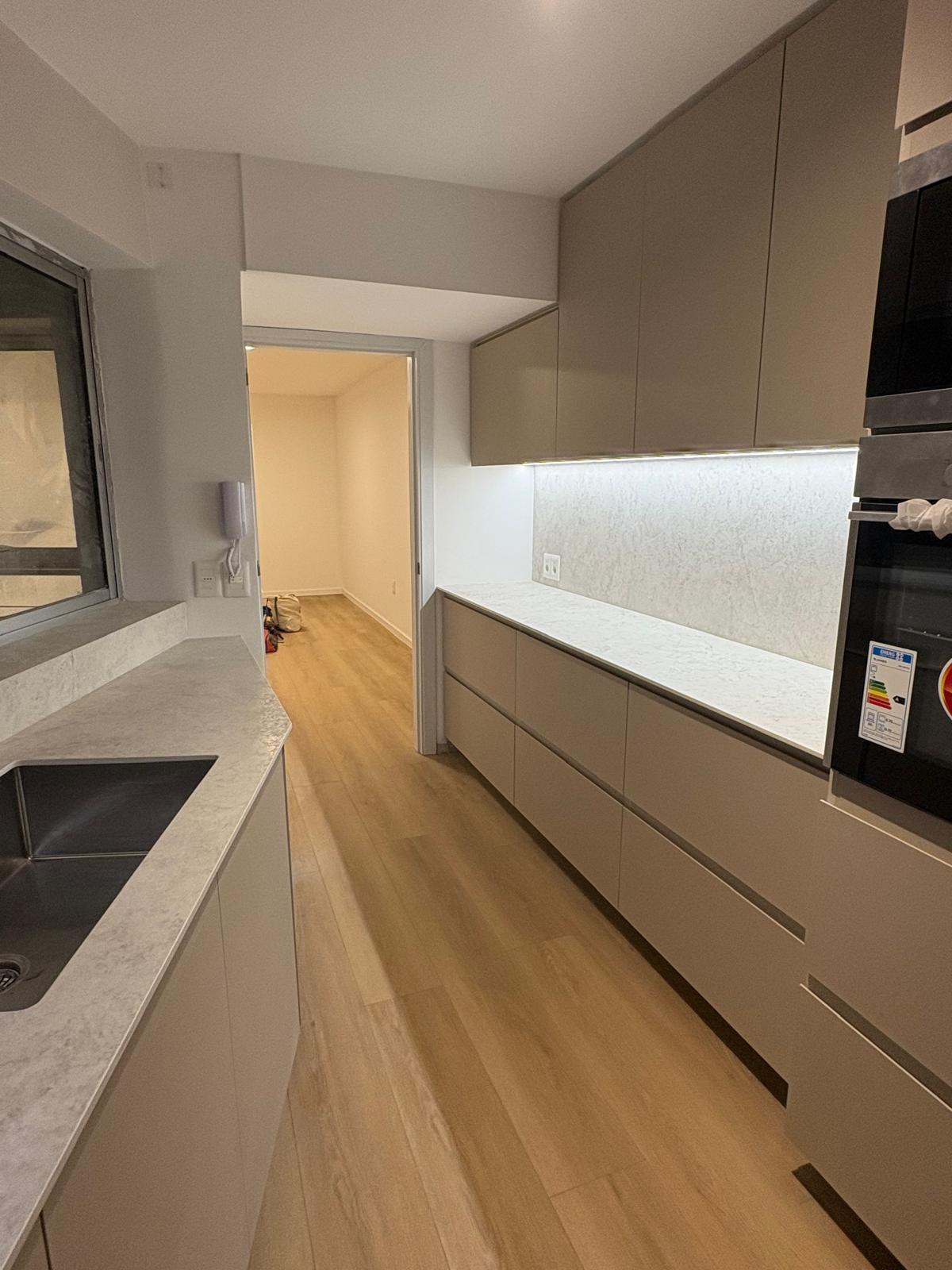 Reforma de cocina con mobiliario a medida en tono Saara e iluminación de la mesada